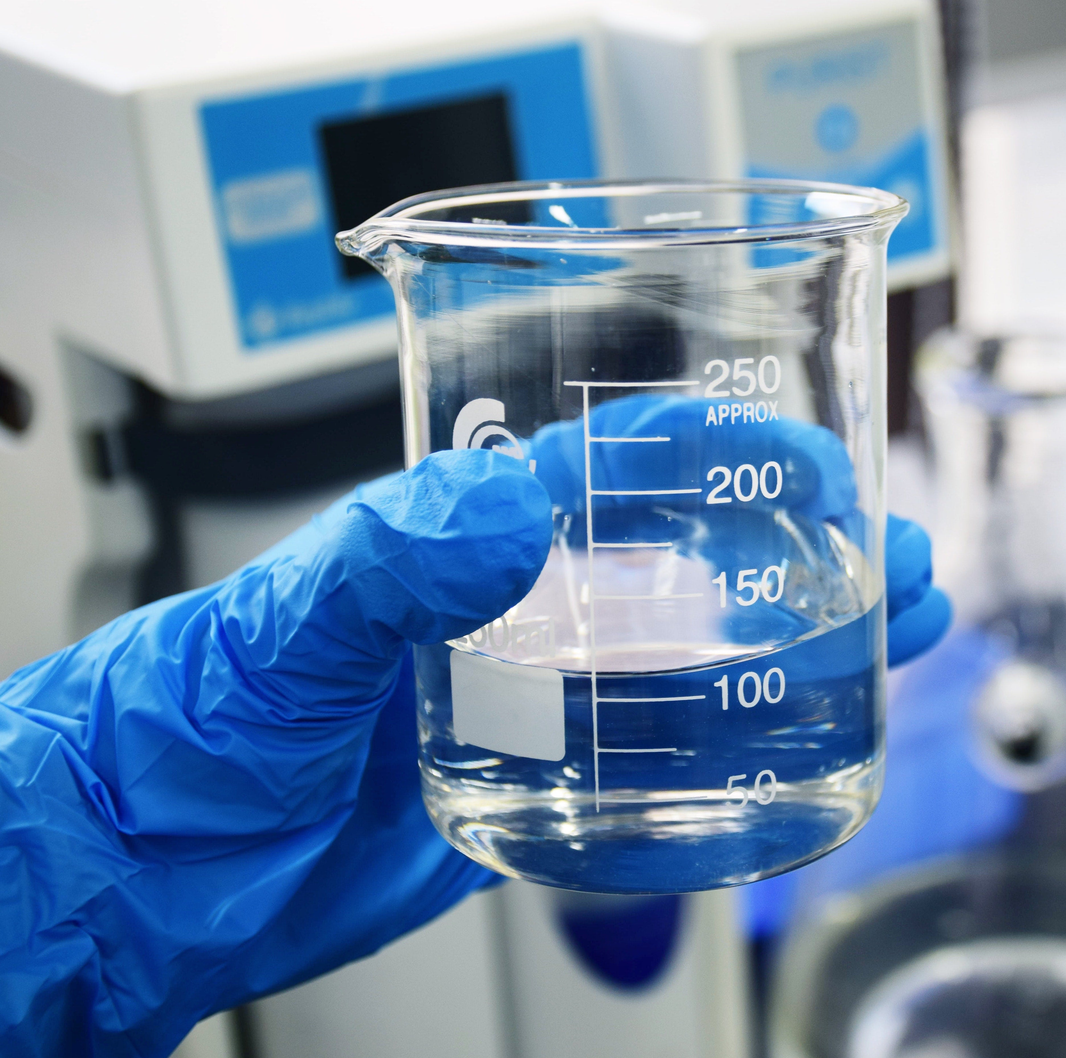 Laboratory Technician Holds a Sample of Water in a Microbiology Laboratory